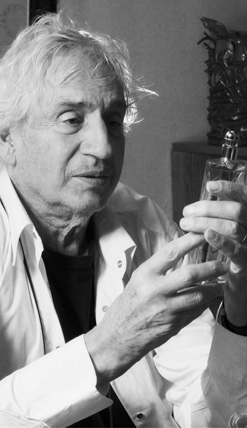 Serge Mansau tenant un flacon de verre